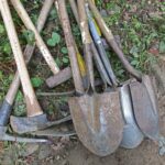 a pile of shovels and forks laying on the ground